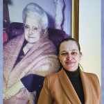 La sig.ra Luciana accanto a un’immagine della sua benefattrice – Foto: Riproduzione